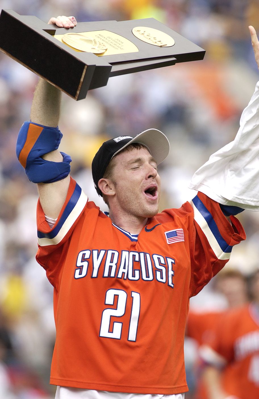 Sean Lindsay in a Syracuse number 21 orange jersey, shouting with joy as he hoists the NCAA championship trophy over his head